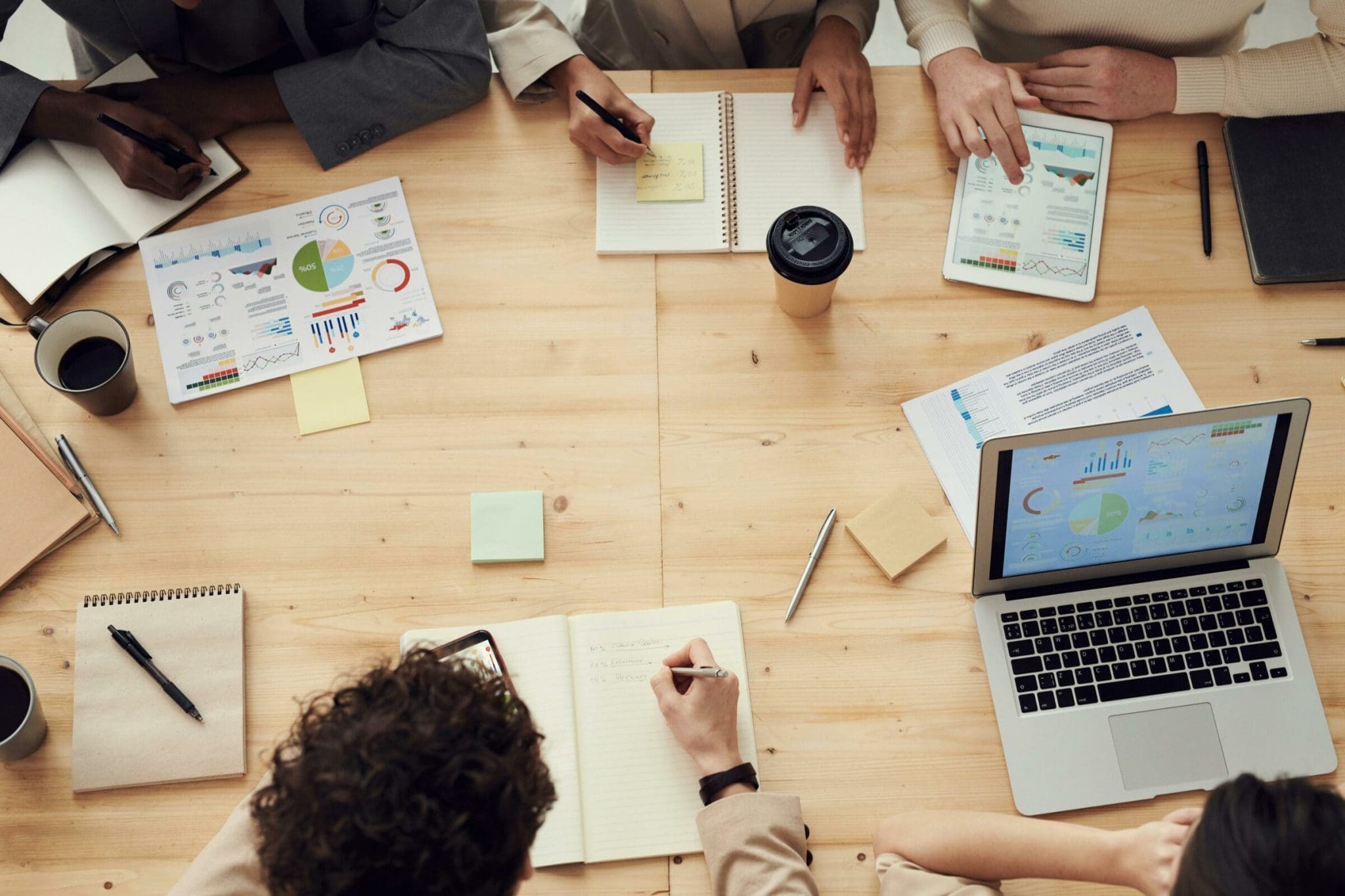 Company culture – an overhead photo of people working on a desk.